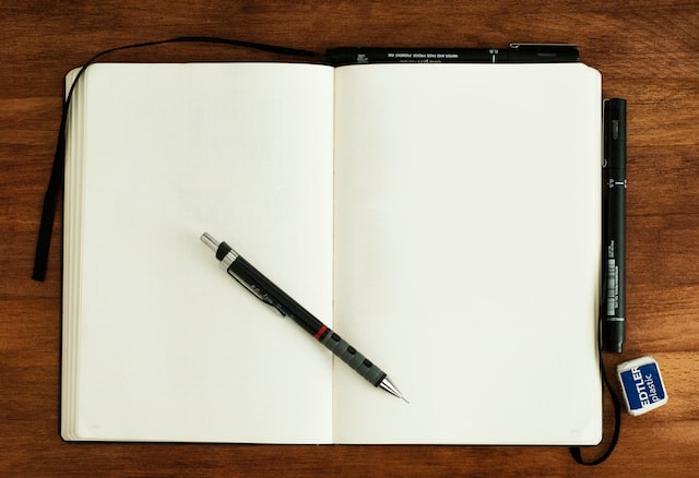 a pen on a white open book